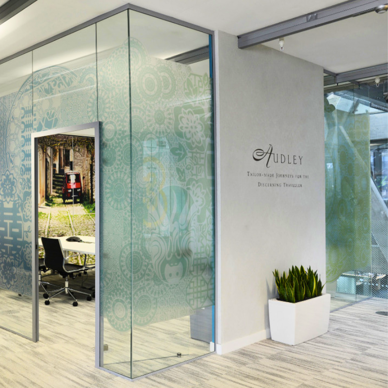 Modern office interior of Audley Travel featuring glass-walled meeting rooms and company branding, representing their successful ERP transformation.